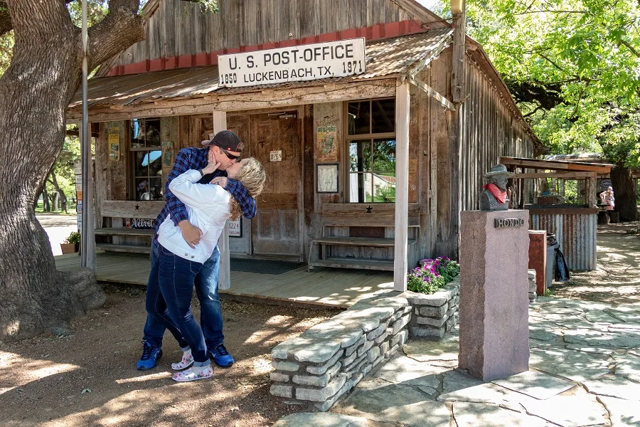 couple dip kissing in front of the Luckenbach Post Office